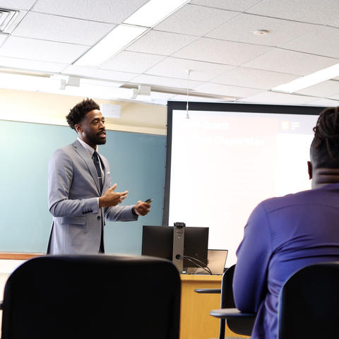 A man gives a presentation in an academic setting