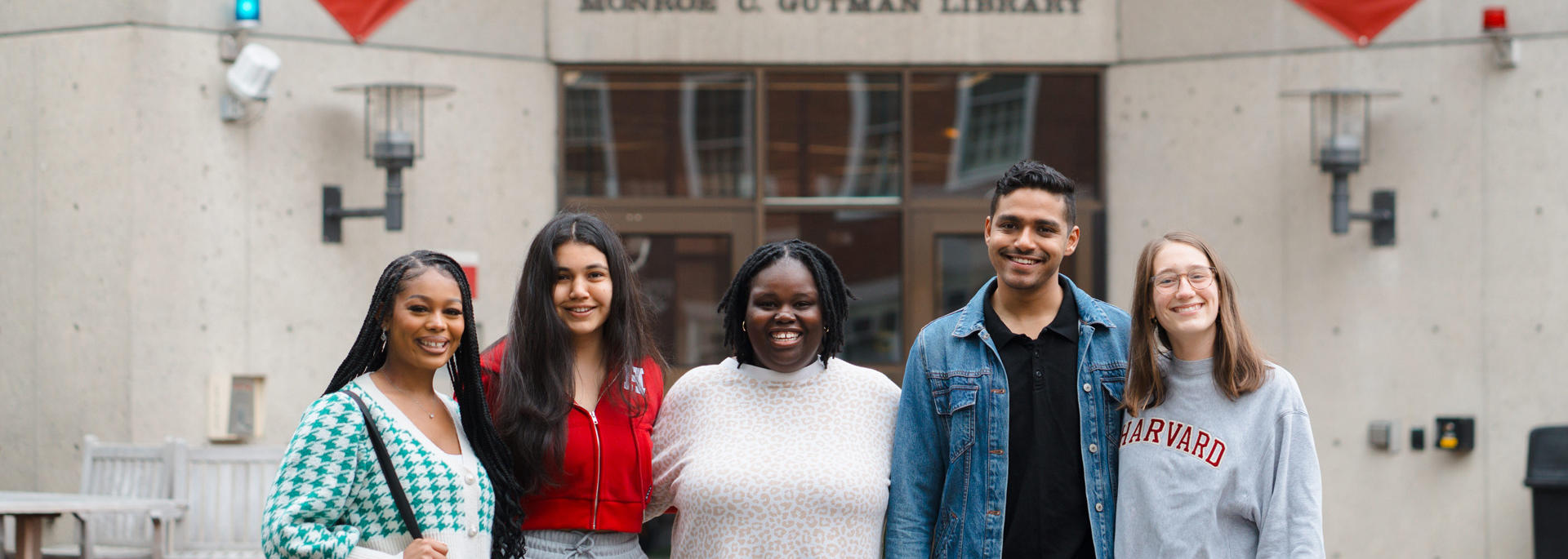 A group of HGSE community members stand in front of Gutman Library